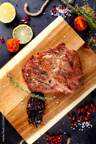 Pork steak with hot pepper and sauce on a cutting board