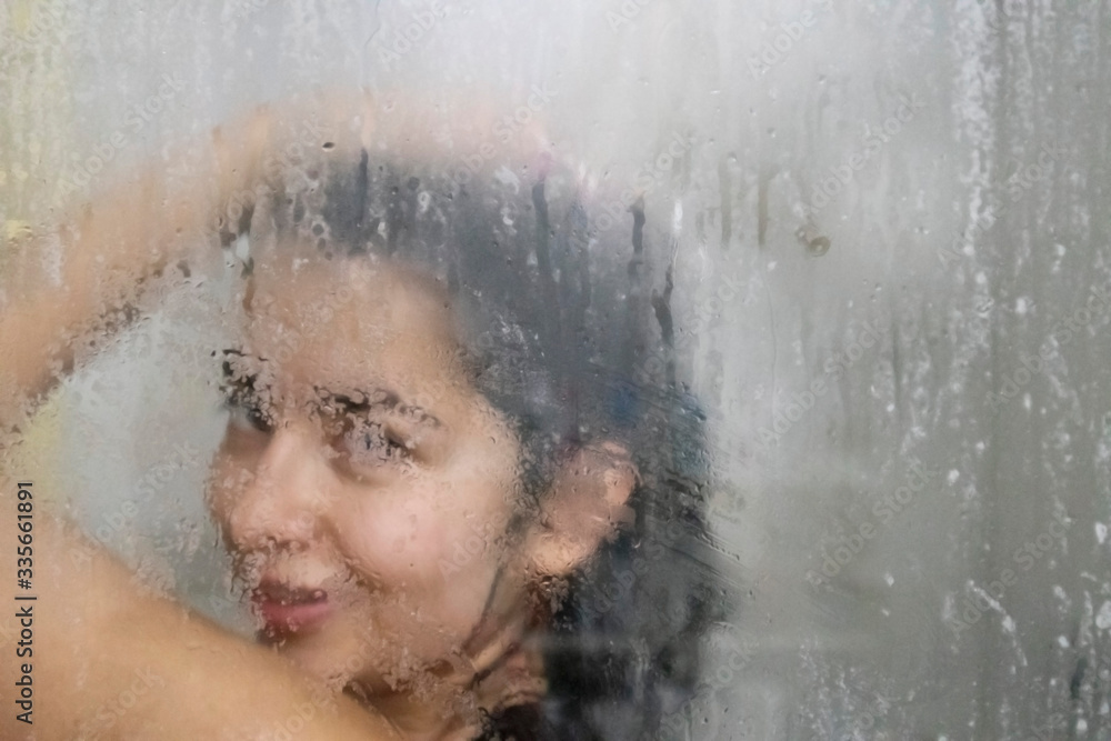 Artistic photo of a beautiful latina woman taking a shower