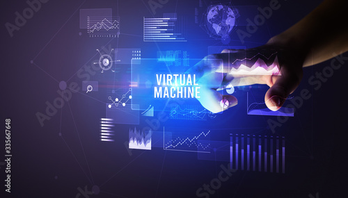 Hand touching VIRTUAL MACHINE inscription, new business technology concept