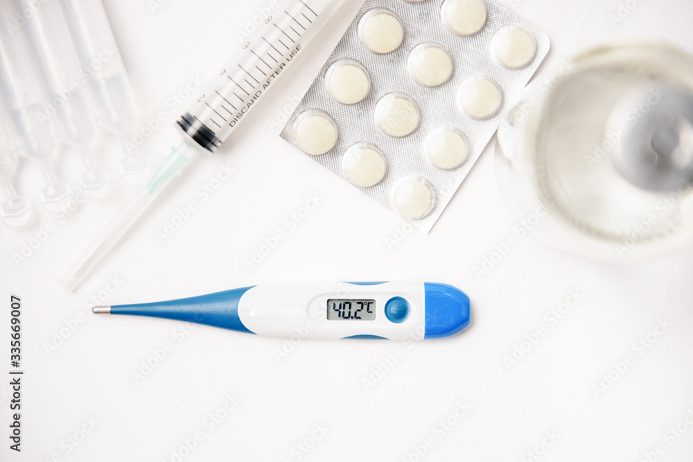 Pills, thermometer and syringes on white background. Coronavirus (COVID-19) epidemic. Flat lay, top view, copy space. Pills, thermometer and syringes on white background. Coronavirus (COVID-19) epidemic. Flat lay, top view, copy space.