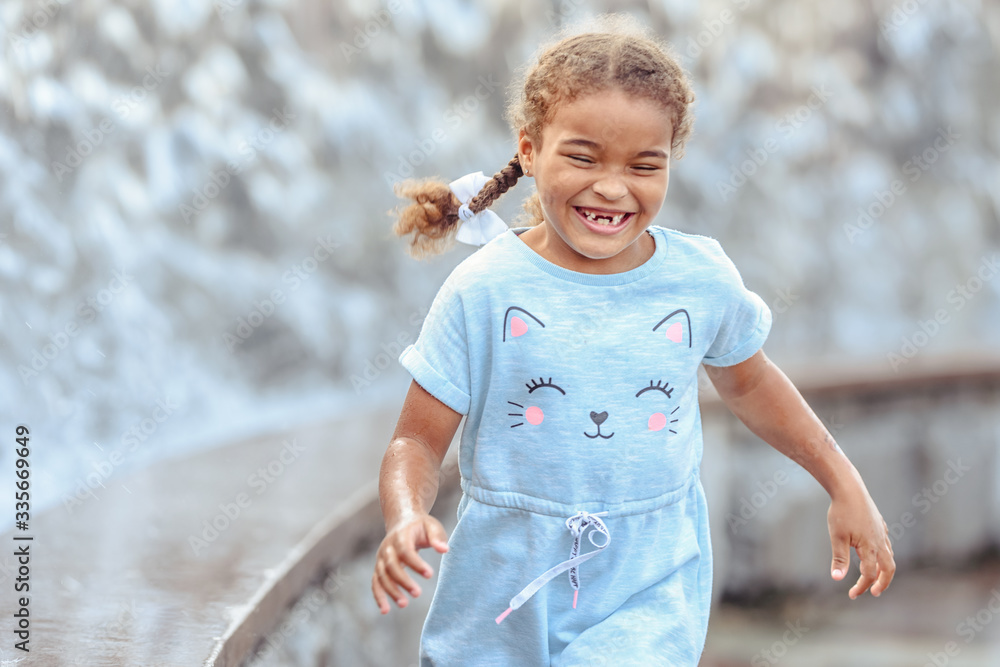 Happy beautiful girl running through the spray of water. Happy beautiful girl running through the spray of water.