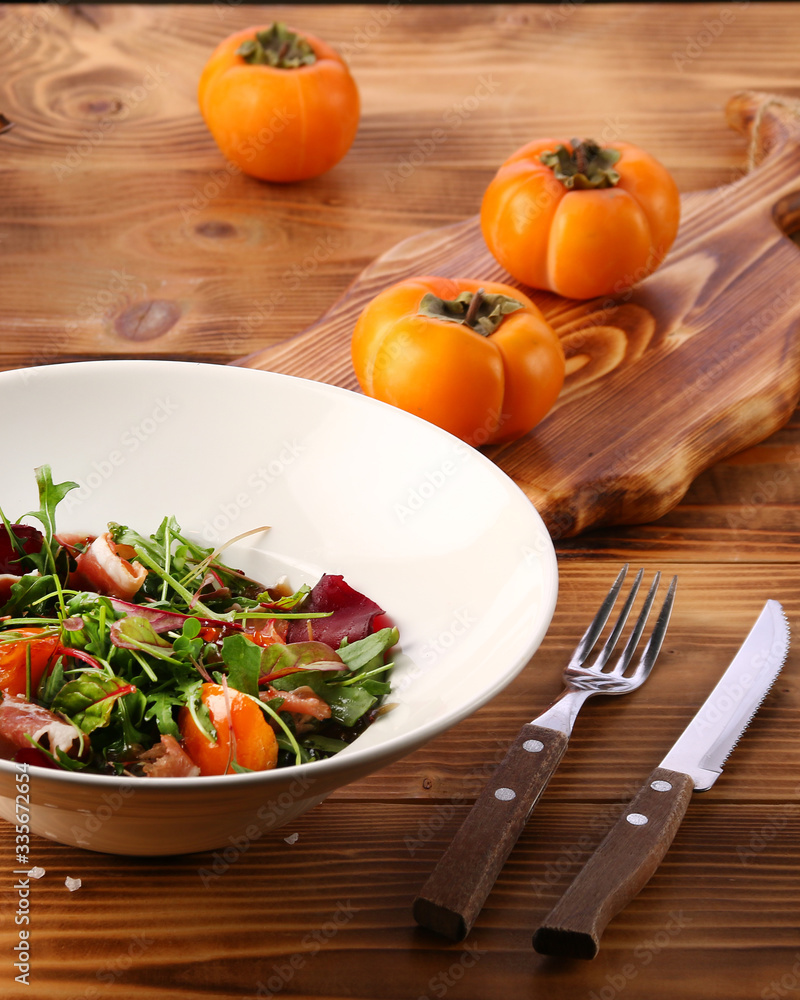 persimmon with meat and persimmon and red wine on wooden table. microgreen and ingredients persimmon with meat and persimmon and red wine on wooden table. microgreen and ingredients