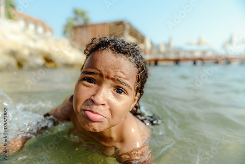 Little girl in danger drowning at the ocean.