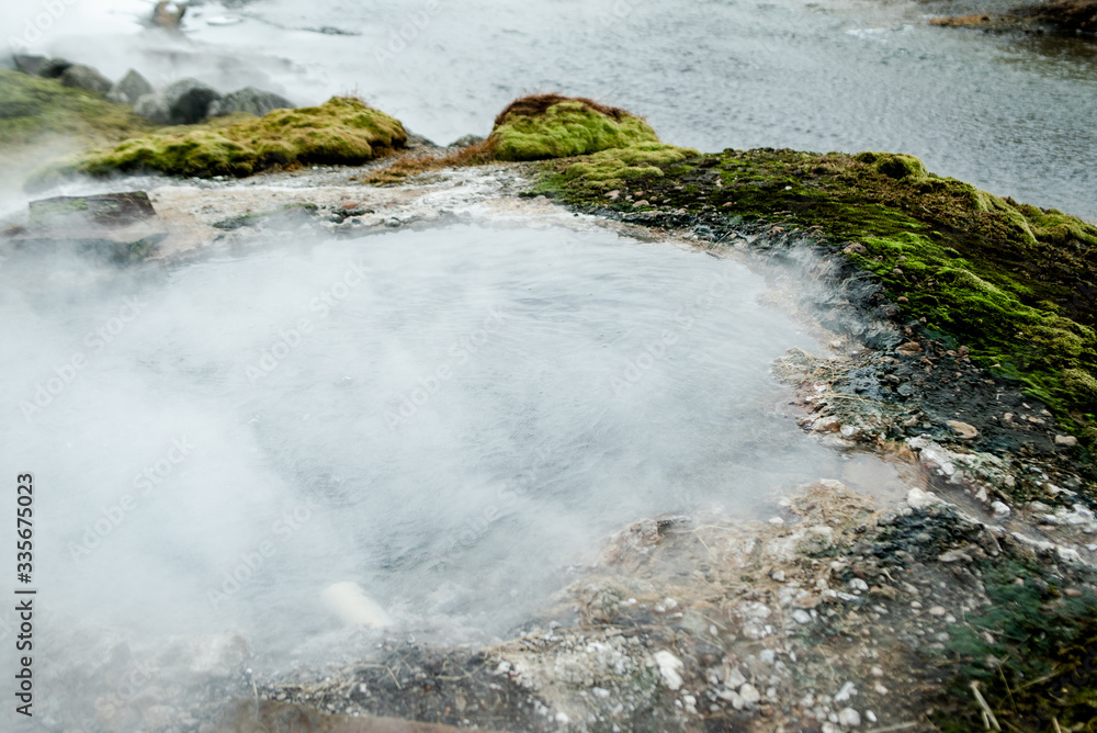 Fototapeta premium The colorful geyser landscape at the Haukadalur geothermal area, part of the golden circle route, in Iceland