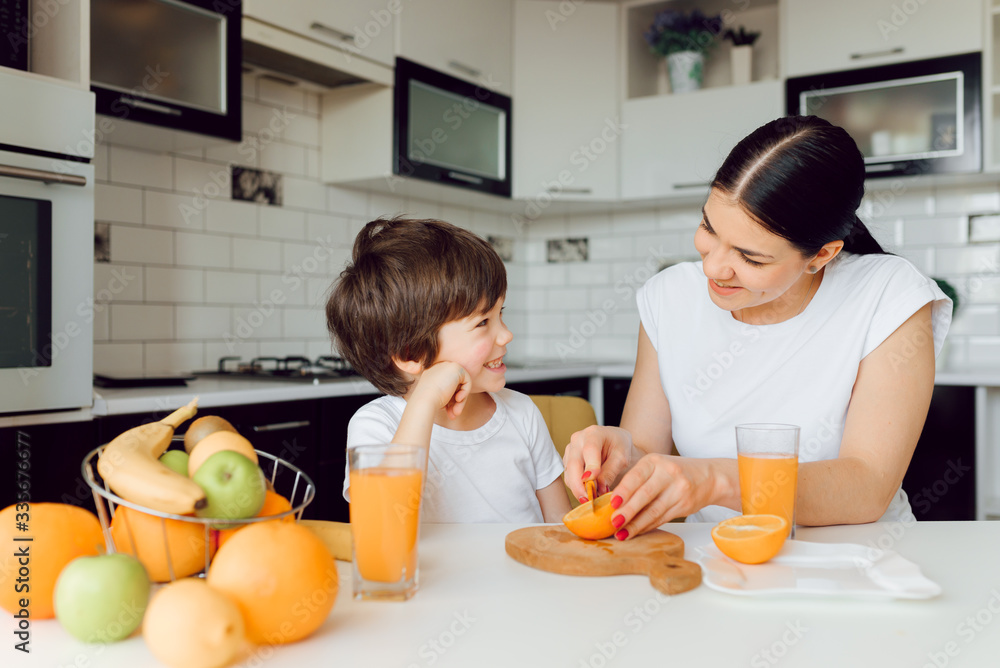 Healthy Eating. mom with baby eating fruits in the kitchen Healthy Eating. mom with baby eating fruits in the kitchen