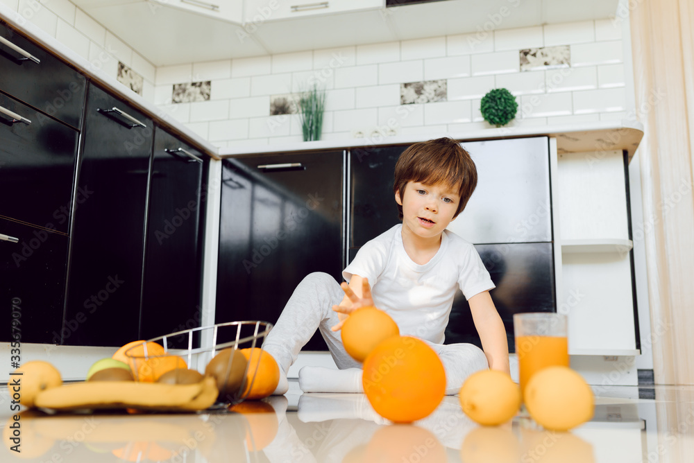 Little boy in the kitchen with a bowl of fresh fruits