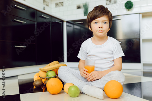 Boy with fruits in the kitchen at home