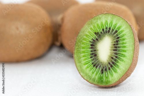 Kiwi fruit is cut in half on the white ground. Kiwi is a fruit that has many vitamins and properties to increase strength in the body.