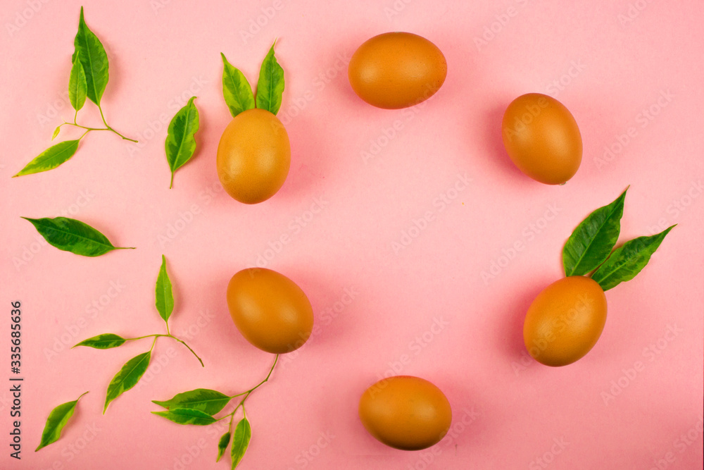 chicken eggs laid out in a circle decorated with green leaves, pink background with place for text, Easter holidays concept,organic food, organic food concept chicken eggs laid out in a circle decorated with green leaves, pink background with place for text, Easter holidays concept,organic food, organic food concept