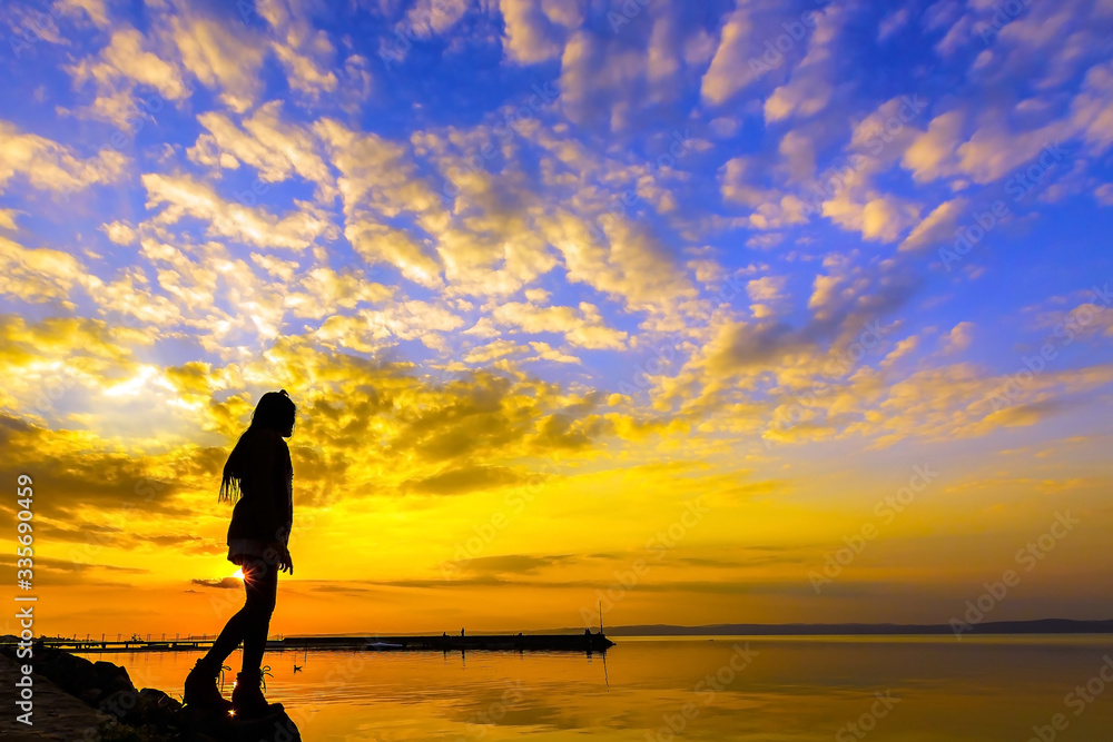 Silhouette of female person at sunset on the beach