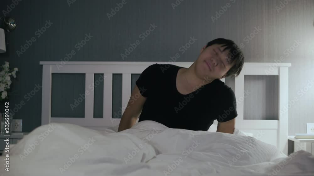 Young asian man wakes up and got out of bed Young asian man wakes up and got out of bed