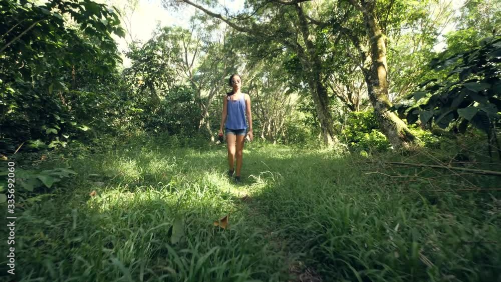 Young woman walking along green path in the forest full of grasses. Young woman walking along green path in the forest full of grasses.