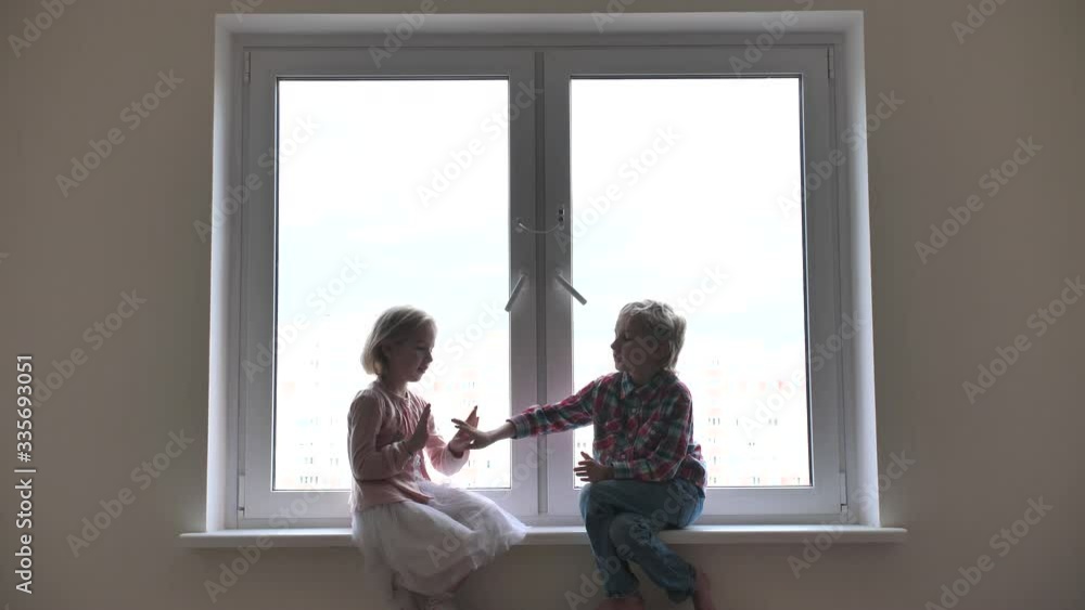 Silhouette of children playing hand on window sill. Silhouette of children playing hand on window sill.