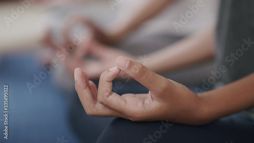 Group of Hand doing yoga exercises with lotus while sitting on yoga mats in a gym, Close-up of hand young woman.Concept of relaxation and meditation