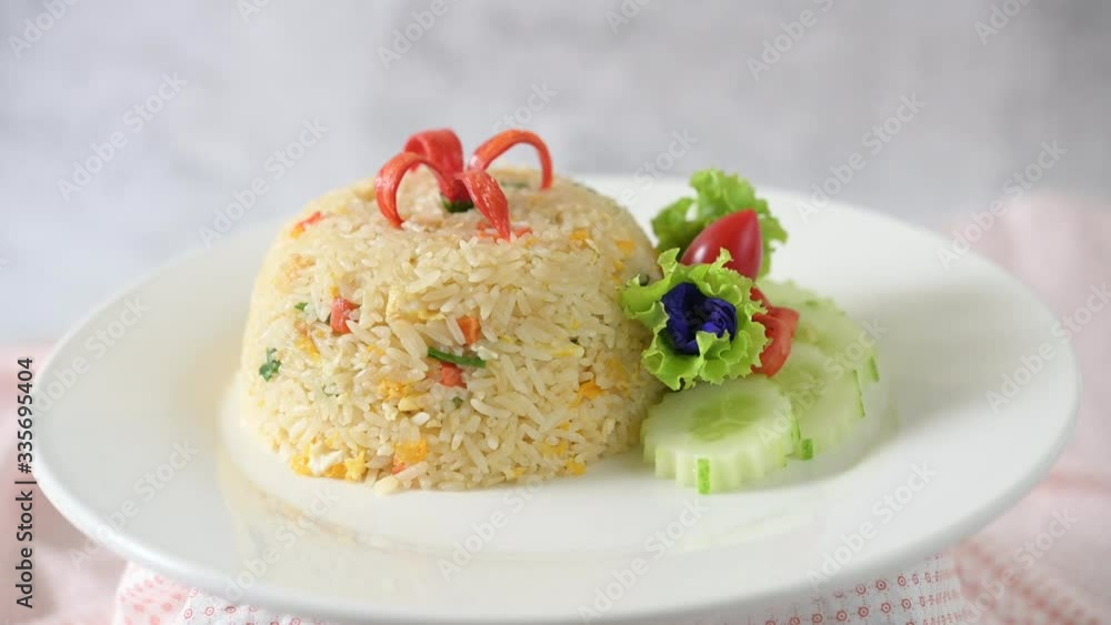 Fried rice with cucumber, tomato salad, butterfly pea and chilies in a white plate Fried rice with cucumber, tomato salad, butterfly pea and chilies in a white plate