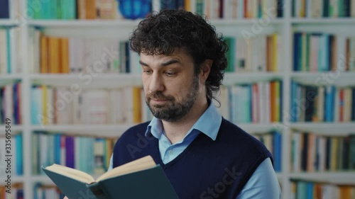 Middle age intelligent businessman reads an interesting science book learning new thinds excited staying at university library. photo