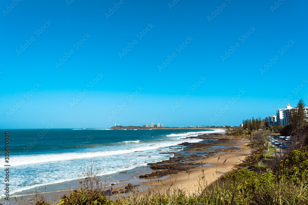 Panoramic view from hill on  rocky beach  Mooloolaba Sunshine Coast on sunny summer day with clear blue sky and breaking ocean waves ocean holiday concept  


