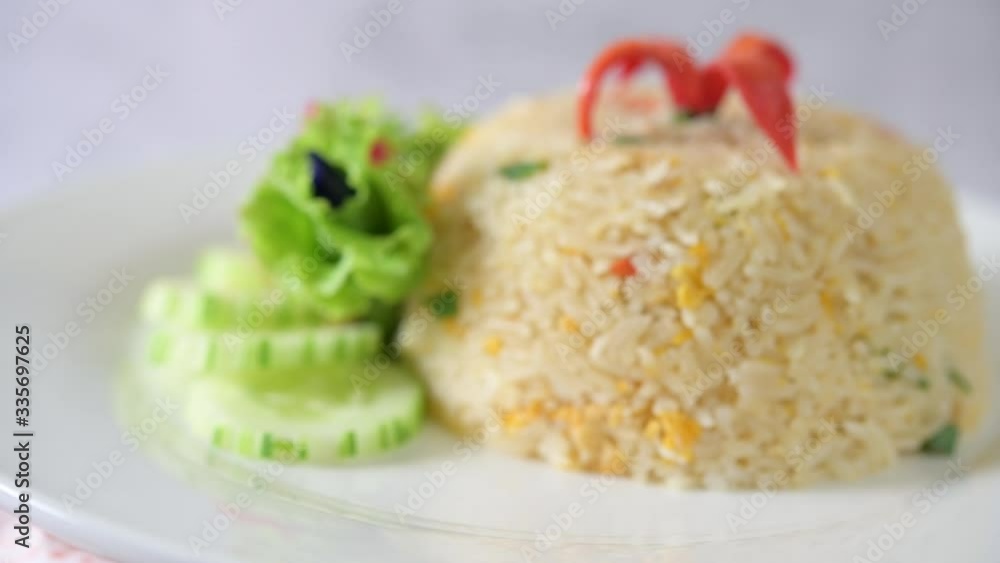 Fried rice with cucumber, tomato salad, butterfly pea and chilies in a white plate Fried rice with cucumber, tomato salad, butterfly pea and chilies in a white plate