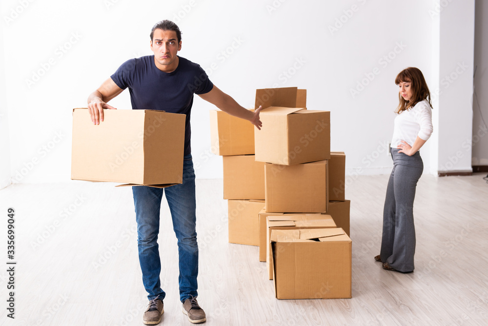 Young pair and many boxes in divorce settlement concept Young pair and many boxes in divorce settlement concept