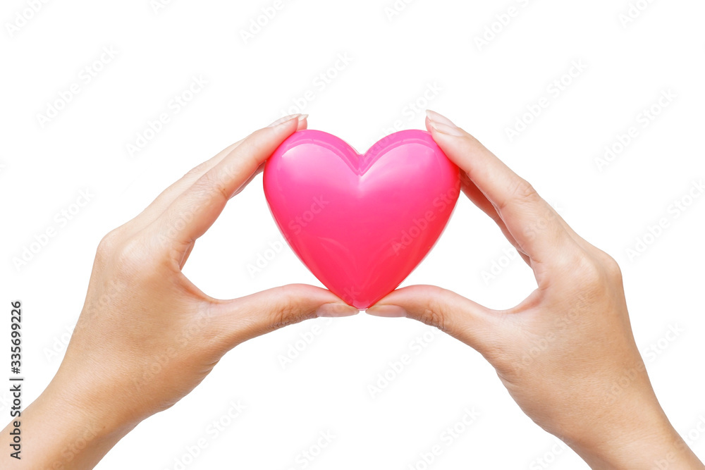 Female hand holding a pink heart isolated on white background Female hand holding a pink heart isolated on white background