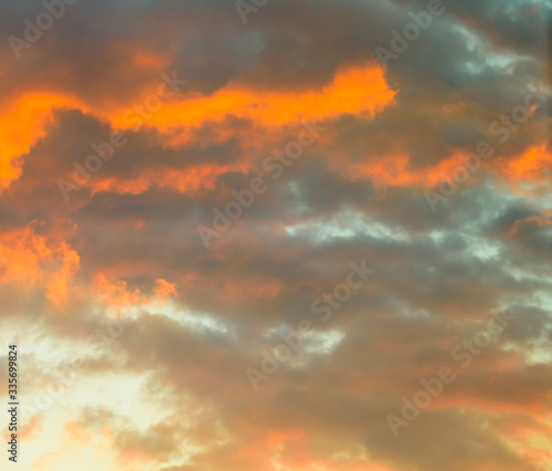 Beautiful puffy clouds at sunset isolated against pastel blue skies © Jim