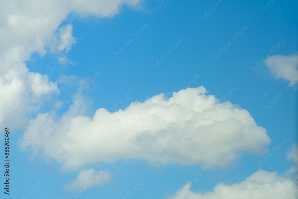 Beautiful puffy clouds at sunset isolated against pastel blue skies Beautiful puffy clouds at sunset isolated against pastel blue skies