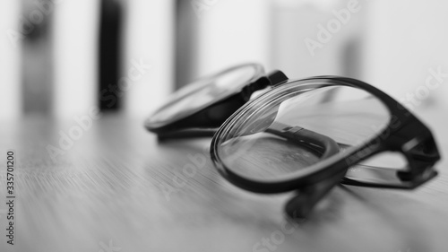 Side view eyeglasses on desk in black white color background.