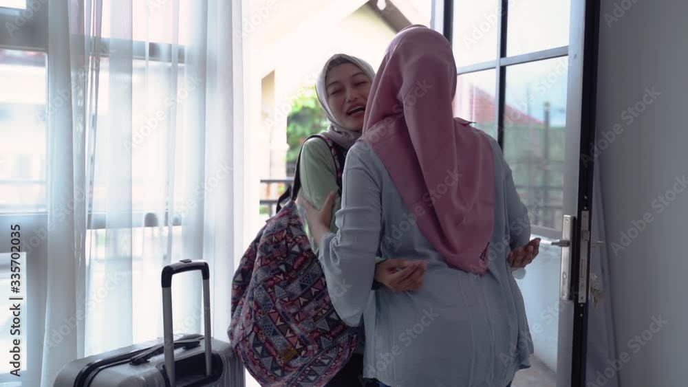 Asian hijab young women are happy to meet their mother when they open the door when they return home Asian hijab young women are happy to meet their mother when they open the door when they return home
