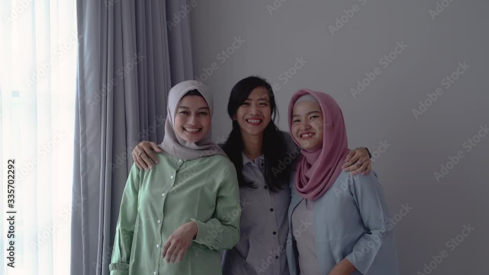 friendship of three smiling women standing next to a window when gathering together friendship of three smiling women standing next to a window when gathering together