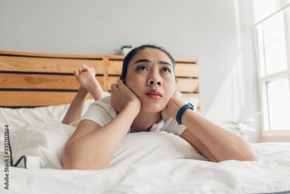 Asian woman is lying on bed and seriously watching drama tv series. Asian woman is lying on bed and seriously watching drama tv series.