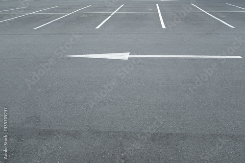 A large white arrow painted on the ground showing the way in an empty car park