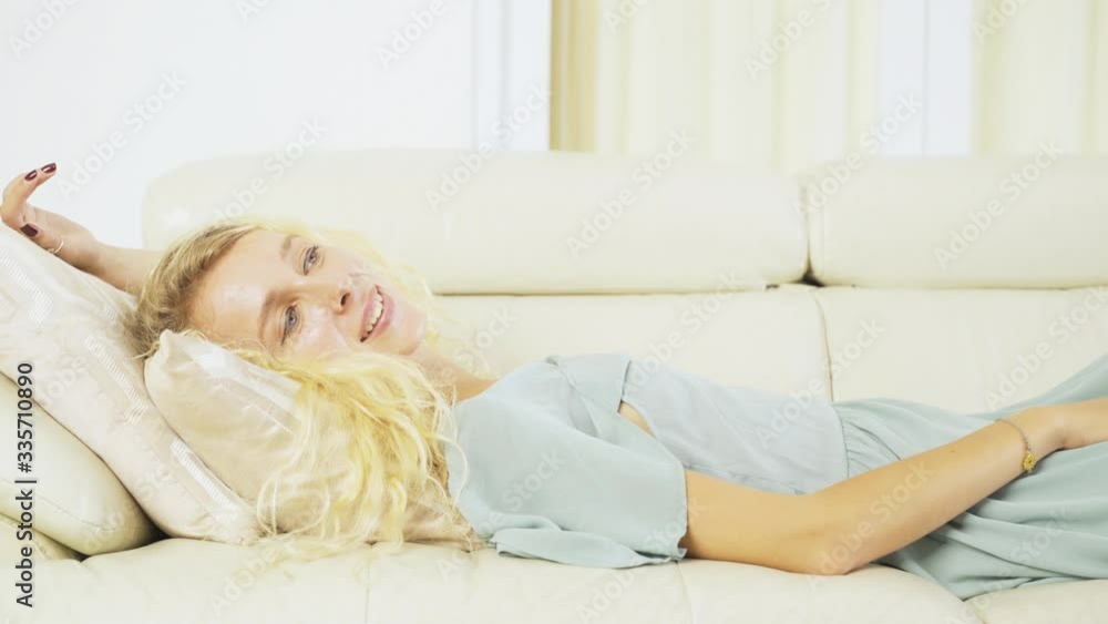 Caucasian woman daydreaming and lying on couch Caucasian woman daydreaming and lying on couch