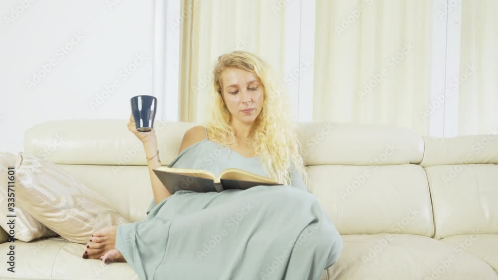 Caucasian woman reads book and drinks coffee Caucasian woman reads book and drinks coffee