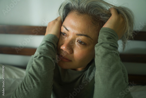 mature lady crisis - middle aged woman with grey hair sad and depressed in bed feeling frustrated and lonely thinking about aging lonely suffering depression © TheVisualsYouNeed