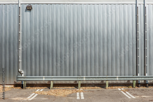 Shiny metal wall on a building with parking spaces in front