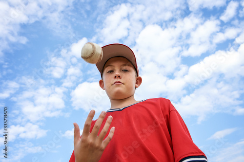 Photography Boy pitcher tossing a baseball in the air, ready to pitch