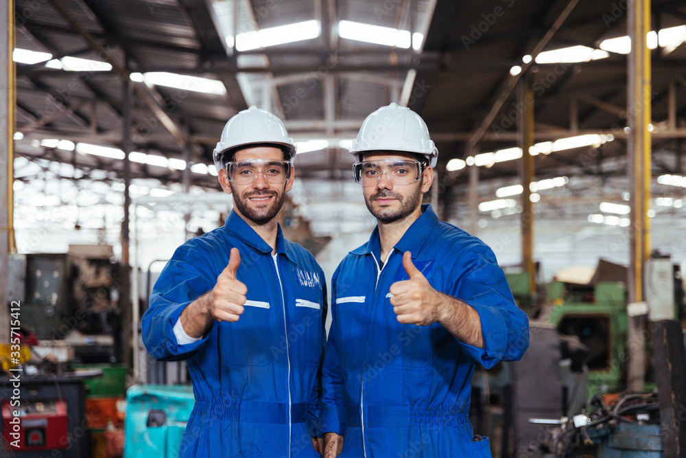 Portrait group of Industry factory maintenance engineer wearing safety uniform and safety helmet standing and smile with thumbs up in factory background. Industry, Engineer, construction concept. Portrait group of Industry factory maintenance engineer wearing safety uniform and safety helmet standing and smile with thumbs up in factory background. Industry, Engineer, construction concept.