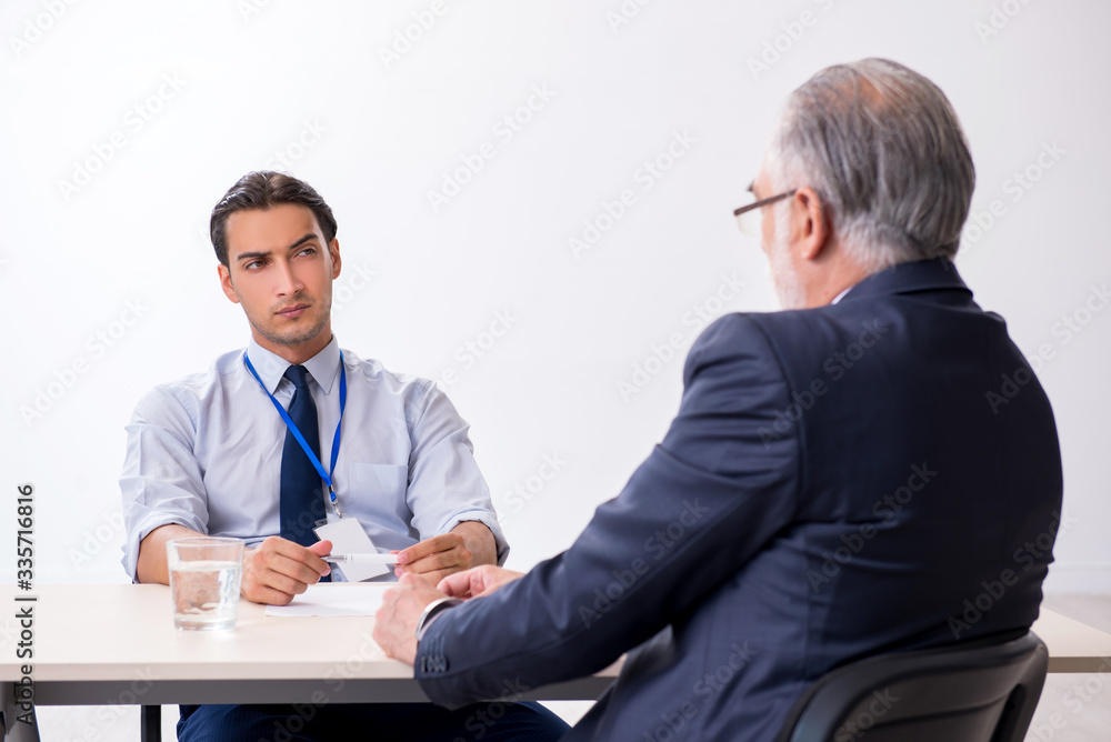 Old businessman meeting with advocate in pre-trial detention Old businessman meeting with advocate in pre-trial detention