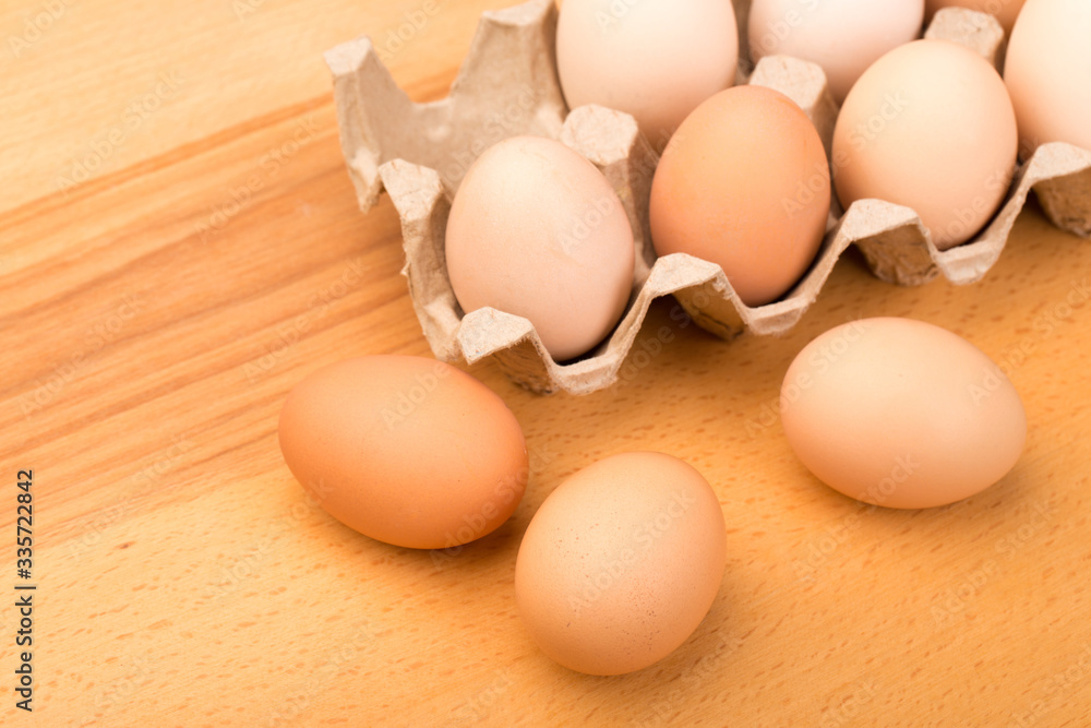 brown chicken eggs in an open cardboard box with eggs on a wooden table. Natural healthy food. brown chicken eggs in an open cardboard box with eggs on a wooden table. Natural healthy food.