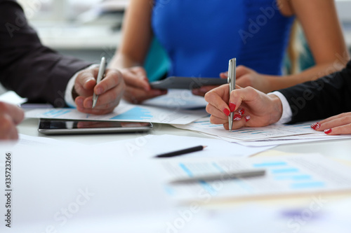 Silver pen lie on important paper at table with group of colleagues in background closeup. Paperwork job trade balance bank credit loan money invest payment irs commerce partnership concept