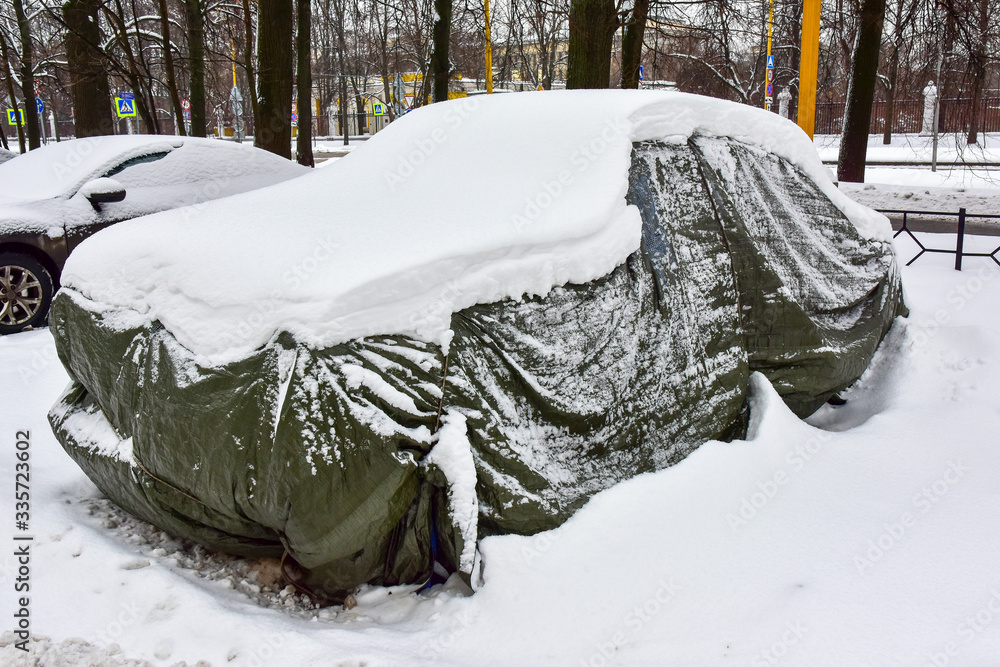 old car covered with case and white snow