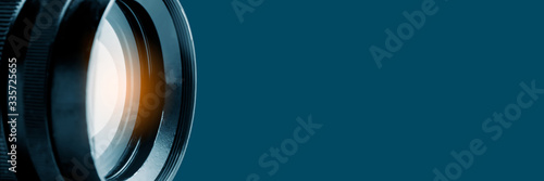 Photo or video camera lens on a blue background. Panoramic image, soft focus. The concept of news, media information