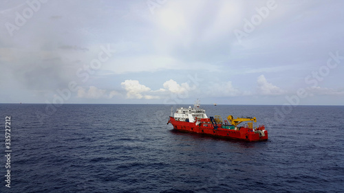 Supply boat (crew boat)  transfer worker and cargo by personnel basket from platform to supply boat of oil and gas industry.