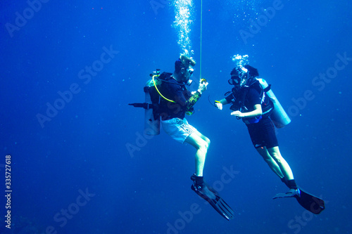 Scuba diver instructing student scuba diver safety stop
