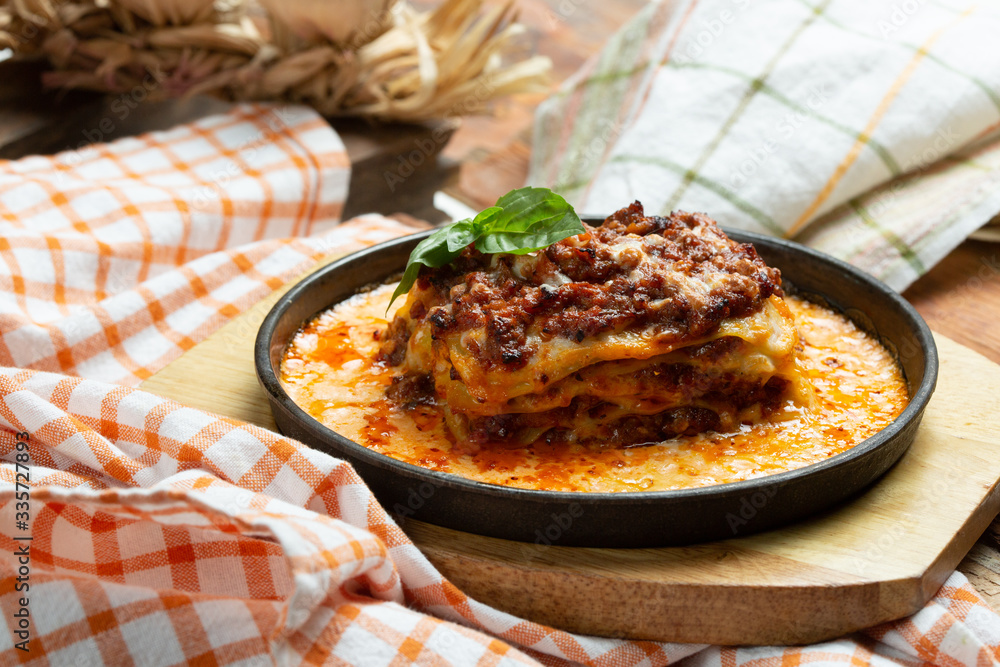 Traditional italian dish. Lasagna made with minced beef bolognese sauce and bechamel sauce topped with basil leaves Traditional italian dish. Lasagna made with minced beef bolognese sauce and bechamel sauce topped with basil leaves