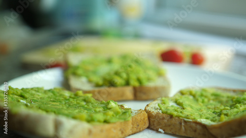 Healthy avocado toasts for breakfast or lunch on a white plate. Vegetarian sandwiches.