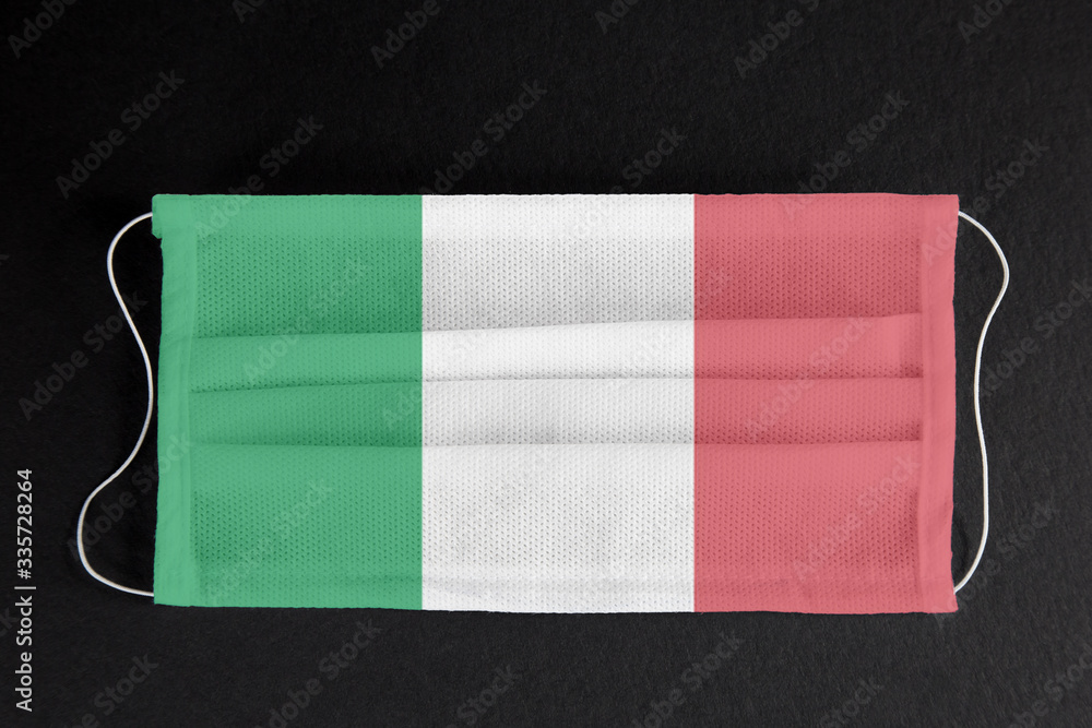 Coronavirus update in Italy. Italian healthcare concept. Flag of Italy printed on medical mask on black background. Covid-19 outbreak. Spread of corona virus in Europe. Coronavirus update in Italy. Italian healthcare concept. Flag of Italy printed on medical mask on black background. Covid-19 outbreak. Spread of corona virus in Europe.