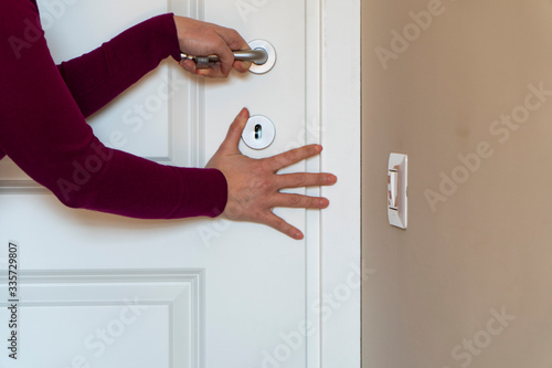 Woman hiding behind the door, woman is very afraid of someone, escape from domestic violence
