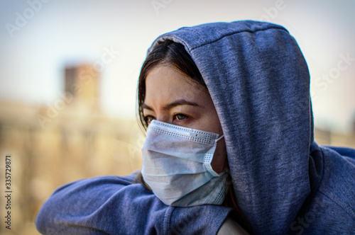 COVID-19 coronavirus pandemic. A woman in a medical mask sits at home in isolation to prevent the spread of a dangerous virus