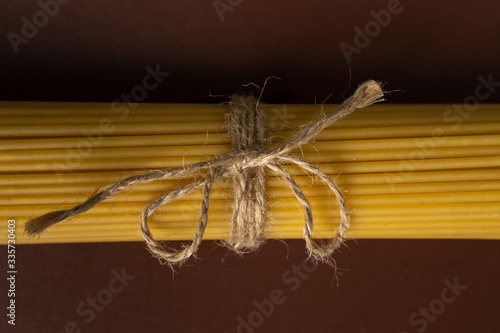 spaghetti on a brown background, tied with a rope,. copy space